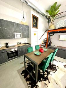 cocina y comedor con mesa y sillas verdes en Estudio céntrico junto Wanda, Ifema y aeropuerto, en Madrid