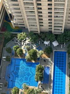 an overhead view of a swimming pool in front of a building at 2BR Luxury Suite with a Garden View in Dubai