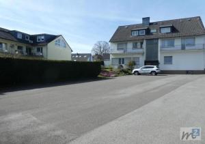 a car parked in a parking lot next to a house at M&M Park Hotel in Radevormwald