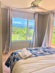 a bedroom with a bed with a large window at 6th Tee Southbroom in Southbroom