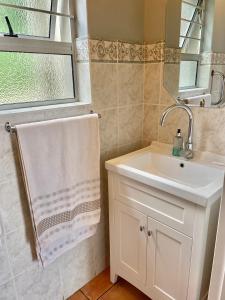 a bathroom with a sink and a mirror at 6th Tee Southbroom in Southbroom +18 photos