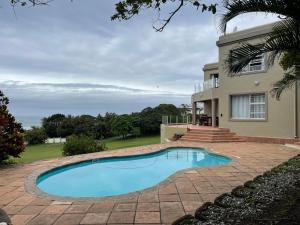 a swimming pool in front of a house at 6th Tee Southbroom in Southbroom