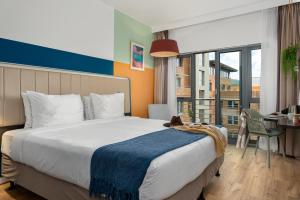 a hotel room with a large bed and a desk with a table at Neighbourgood Newlands in Cape Town
