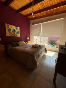 a bedroom with a bed and a large window at Lo de Lili a pasos del Centro de Tandil in Tandil +11 photos