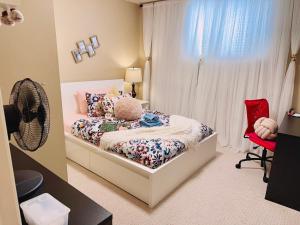 a bedroom with a bed and a red chair at Scorpio House Langley - Semi-basement Suite in Langley +95 photos