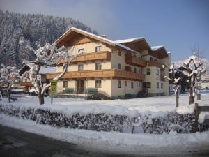 ein großes Gebäude mit Schnee davor in der Unterkunft Gästehaus Schwoagerhof in Fügen