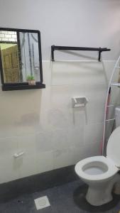 Un baño con inodoro y ventana. en Ummi Homestay, en Kampong Batu Tiga