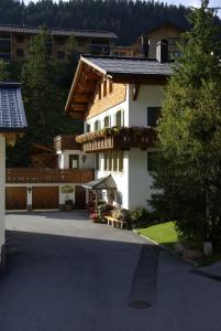 um edifício branco com uma varanda com flores em Hotel Pension Alpenrose em Lech am Arlberg