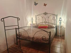 een slaapkamer met een bed met een metalen bedframe bij Casa García Pérez in Las Lagunetas