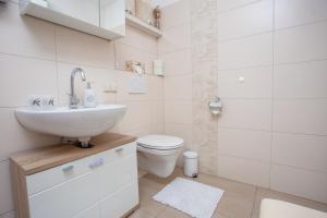 a white bathroom with a sink and a toilet at Schnelli Appartement Schladming in Schladming