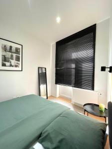 a bedroom with a bed and a window with black blinds at Cosy apartment in Brussels in Brussels