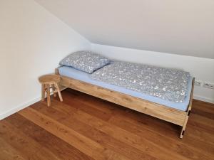 Una cama pequeña en una habitación con un taburete. en Haus im Glück, en Freigericht