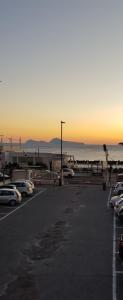 a parking lot with cars parked in front of the ocean at GIOIA Holiday Home in Torre del Greco