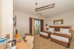 een hotelkamer met twee bedden en een bureau bij Hotel Boursier 1 & Spa in Istanbul +30 foto's