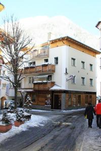 eine Gruppe von Menschen, die vor einem Gebäude eine Straße hinuntergehen in der Unterkunft Dorfplatzl in Ischgl