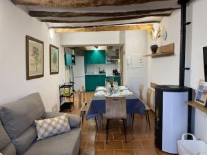 a living room with a couch and a table and a kitchen at Apartament2 Ca la Maru amb jacuzzi comunitari in Sant Antolí i Vilanova