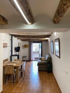 a living room with a table and a couch at Apartament2 Ca la Maru amb jacuzzi comunitari in Sant Antolí i Vilanova