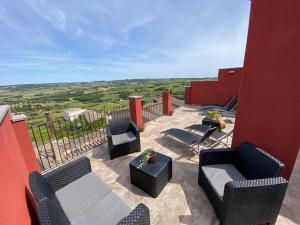 a patio with two chairs and a table and chairs at Apartament2 Ca la Maru amb jacuzzi comunitari in Sant Antolí i Vilanova