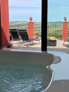 a pool of water with two chairs and a table at Apartament2 Ca la Maru amb jacuzzi comunitari in Sant Antolí i Vilanova