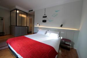a bedroom with a bed and a lamp on the wall at H Complutum in Alcalá de Henares