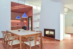 a dining room with a table and chairs and a fireplace at Casa Vista Verde by LovelyStay in Sesimbra +18 photos