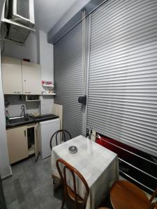 シェンジンにあるS Apartmentのキッチン(テーブル、椅子付)、大きな窓が備わります。