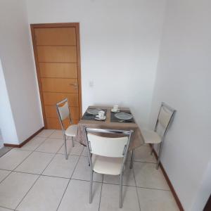 a dining room with a table and chairs and a door at Apartamento Taguatinga Sul 2 quartos com garagem elevador 1 a 4 hospedes sem taxas in Brasilia