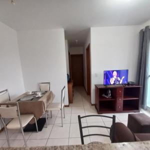 a living room with a dining table and a television at Apartamento Taguatinga Sul 2 quartos com garagem elevador 1 a 4 hospedes sem taxas in Brasilia