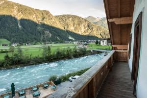 einen Balkon mit Blick auf den Fluss und die Berge in der Unterkunft Hostel Chillertal in Mayrhofen