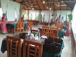 a restaurant with tables and chairs and people in the background at BADAMI HERITAGE RESORT in Badami