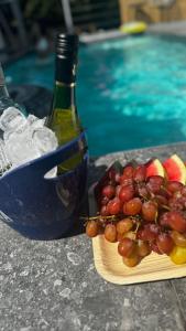 a plate of fruit next to a bottle of wine at Coco villa & resort in Qiryat Ata