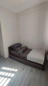 a bed in a room with a wooden floor at natural minimalist apt ice bsd in Cilandak