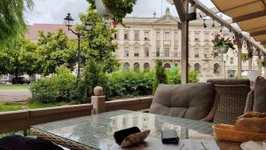 a patio with a glass table and a couch and a building at Apartament Panoramiczna "Sloneczny Balkon z Widokiem na caly Szczecin" in Szczecin