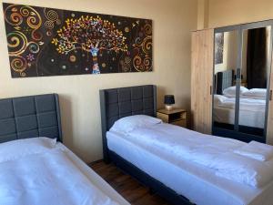 Un dormitorio con dos camas y un cuadro en la pared. en Ferienwohnung Michelangelo NETFLIX, en Eisenach