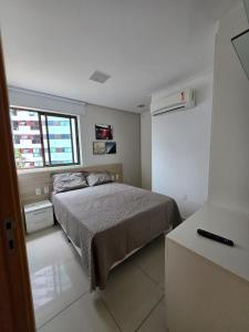 una piccola camera da letto con un letto e una finestra di Apartamento Graças 108 a Recife