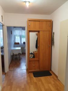 a room with a wooden cabinet with a mirror at Apartament Lidka Zaprasza in Kwidzyn