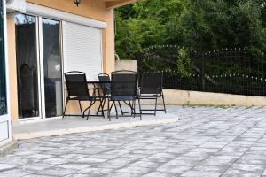 - un ensemble de chaises assises autour d'une table sur une terrasse dans l'établissement Apartment Germia, à Pristina 2 autres photos