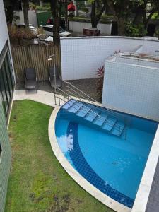 una piscina in un cortile con due sedie accanto di Apartamento Graças 108 a Recife