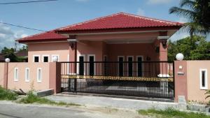 a small pink house with a black gate at Larut Tin Homestay in Taiping