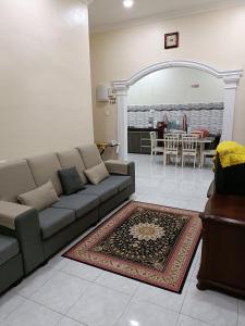a living room with a couch and a table at Larut Tin Homestay in Taiping
