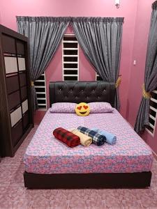 a bed in a pink room with avenge at Larut Tin Homestay in Taiping +3 photos