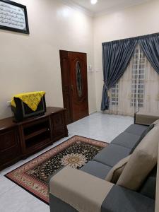 a living room with a couch and a table at Larut Tin Homestay in Taiping