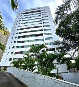 un alto edificio bianco con palme di fronte di Apartamento Graças 108 a Recife