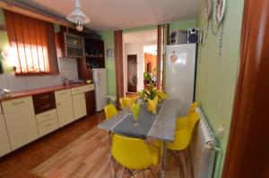 a kitchen with a table and yellow chairs at Casa Irina in Piatra Neamţ