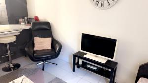 a room with a desk and a chair and a television at Joli Appartement au cœur de la ville in Avignon