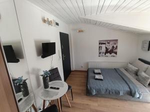 a small bedroom with a bed and a table at Royal EvitaBocelli Spodek by walk self check - in in Katowice