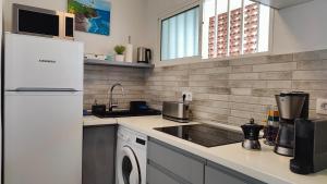 Una cocina con un frigorífico blanco y un lavavajillas. en MAH Maspalomas Atlantic View, en Maspalomas