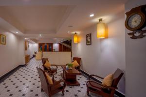 a living room with a table and chairs and a clock at Skyline Boutique Hotel in Phnom Penh