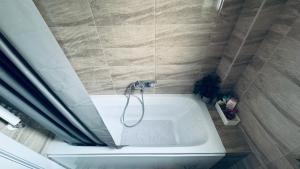 a bathroom with a bath tub with a shower at Adam Home Ap in Fălticeni +10 photos
