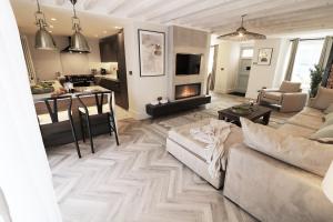 a living room with a couch and a fireplace at Tudor Cottage, Hot Tub, Sleeps 8 in Llandudno